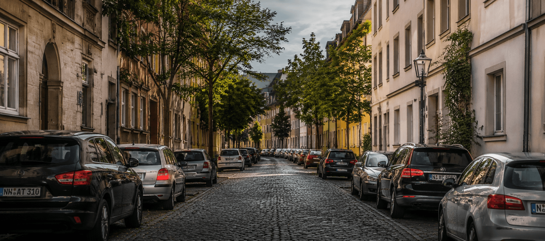 Deutsche Altbau-Straße mit Kopfsteinpflaster und parkenden Autos